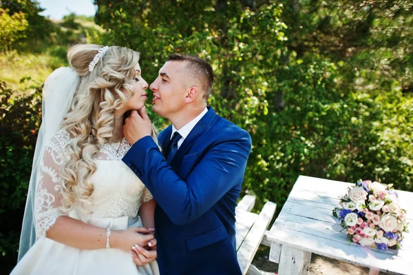 Verheugd huwelijksfeest paar verliefd op zonnige dag zit op houten tabl — Stockfoto