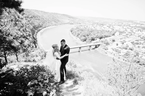 Feliz boda pareja en amor en día soleado estancia cerca acantilado con l — Foto de Stock