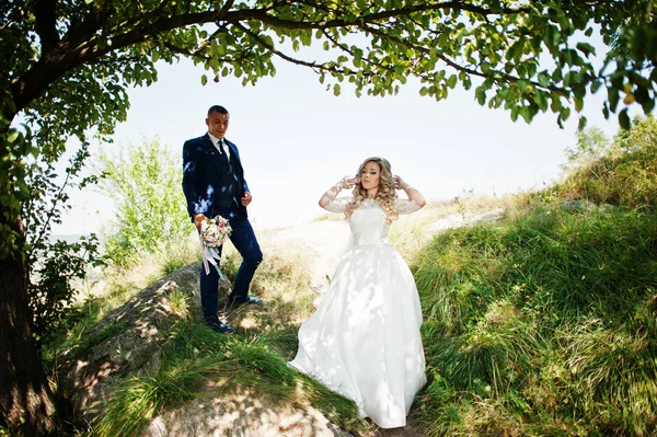 Lyckliga bröllopsparet i kärlek på solig dag bo nära träd. — Stockfoto
