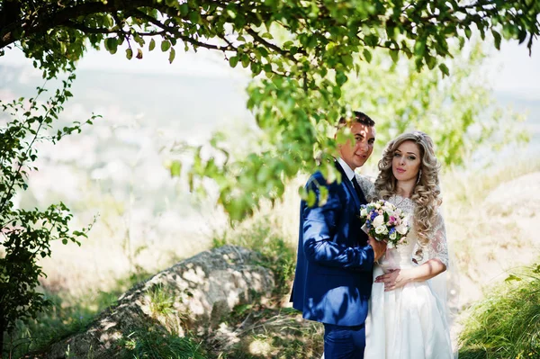 Verheugd huwelijksfeest paar verliefd op zonnige dag verblijf in de buurt van bomen. — Stockfoto