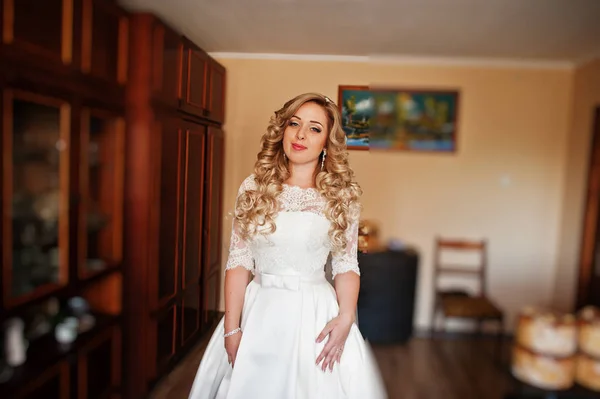 Schöne blonde lockige Braut bei ihrem Hochzeitskleid, Vorbereitung auf — Stockfoto