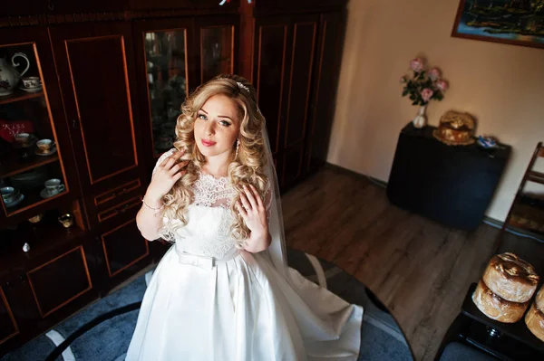 Schöne blonde lockige Braut bei ihrem Hochzeitskleid, Vorbereitung auf — Stockfoto