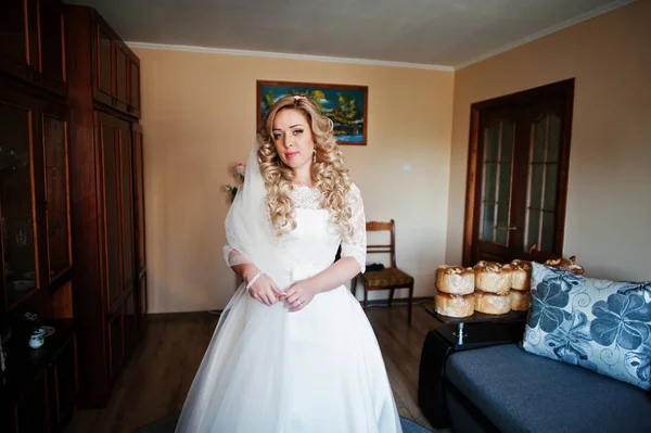 Schöne blonde lockige Braut bei ihrem Hochzeitskleid, Vorbereitung auf — Stockfoto