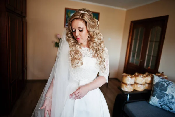 Schöne blonde lockige Braut bei ihrem Hochzeitskleid, Vorbereitung auf — Stockfoto