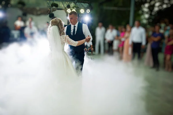 Amazing first wedding dance of newlyweds at heavy smoke. — Stock Photo, Image