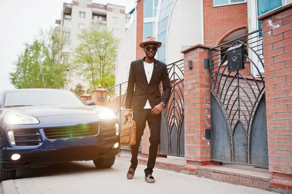 Stylish black man at glasses with hat, wear on suit with handbag