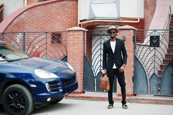 Stylish black man at glasses with hat, wear on suit with handbag