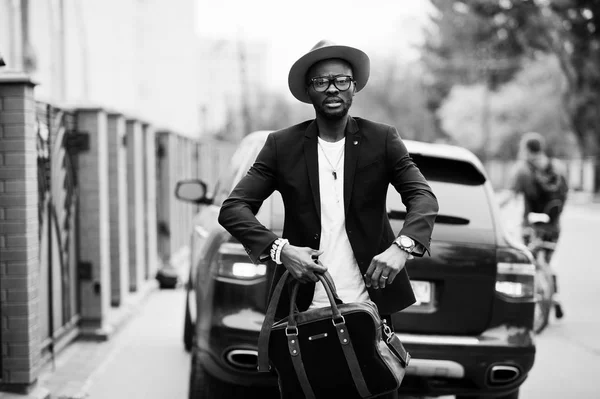 Stylish black man at glasses with hat, wear on suit with handbag