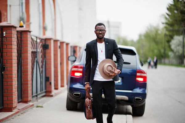 Stylowy czarny człowiek o okulary, kapelusz, nosić na garnitur z torebka — Zdjęcie stockowe
