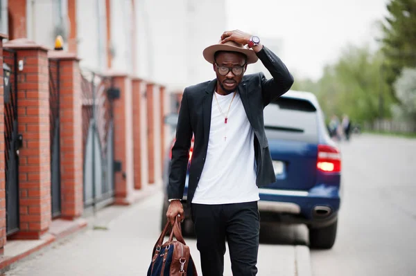 Snygg svart man på glasögon med hatt, bära på kostym med handväska — Stockfoto