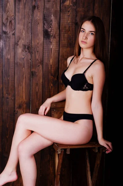 Portrét sexy brunetka v černé spodní prádlo poblíž židle na — Stock fotografie