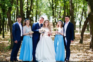 Düğün çifti ile mavi nedime elbiseler ve en iyi adamın ha