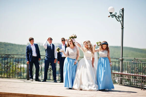 Wedding couple with bridesmaids on blue dresses and best mans ha
