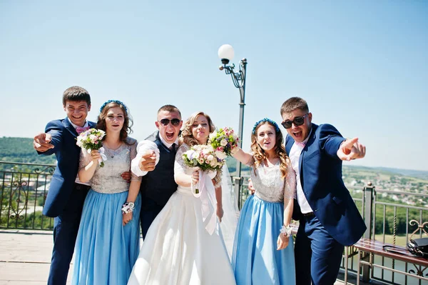 Bruidspaar met bruidsmeisjes op blauwe jurken en beste mans ha — Stockfoto