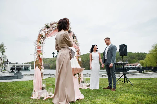 Casal encantador na moda jovem com mestre de discurso de ce de casamento — Fotografia de Stock