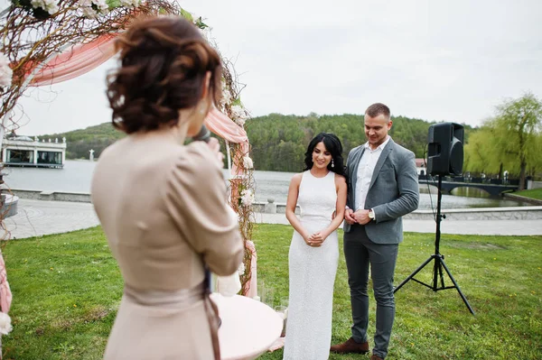 Joven pareja encantadora de moda con el maestro del discurso de boda ce — Foto de Stock