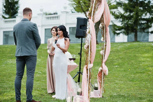 Jeune couple charmant à la mode avec maître de la parole de mariage ce — Photo