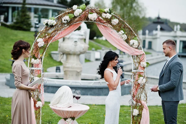 Jeune couple charmant à la mode avec maître de la parole de mariage ce — Photo