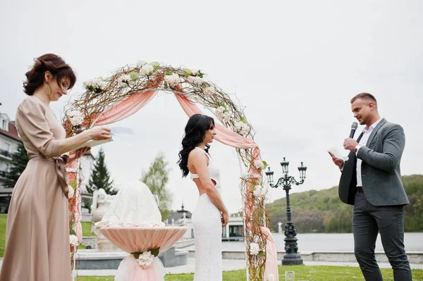 Joven pareja encantadora de moda con el maestro del discurso de boda ce —  Fotos de Stock