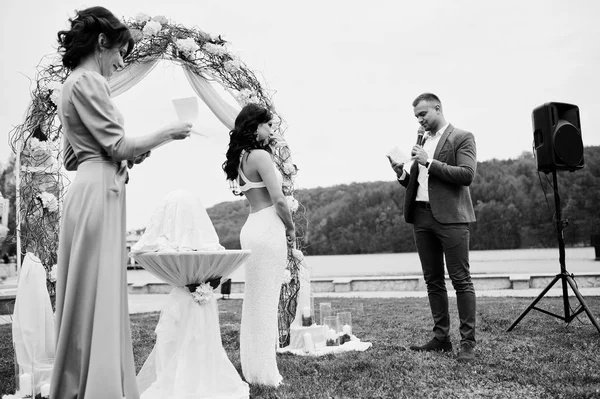 Joven pareja encantadora de moda con el maestro del discurso de boda ce —  Fotos de Stock