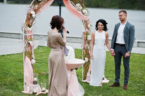 Joven pareja encantadora de moda con el maestro del discurso de boda ce — Foto de Stock