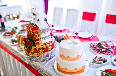 Yeni evliler, masada iki düğün pastaları.