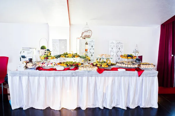 Wedding reception catering table with different fruits and cakes