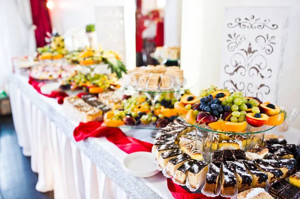 Wedding reception catering table with different fruits and cakes — Stock Photo, Image