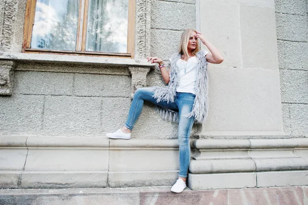Stylische blonde Frau tragen Jeans und Mädchen ärmellose mit weißen — Stockfoto
