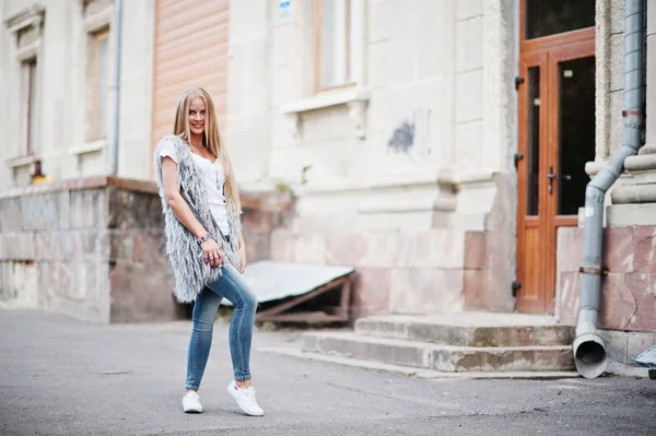 Stylische blonde Frau tragen Jeans und Mädchen ärmellose mit weißen — Stockfoto