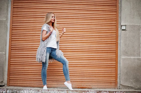 Stylische blonde Frau tragen Jeans und Mädchen ärmellose mit weißen — Stockfoto