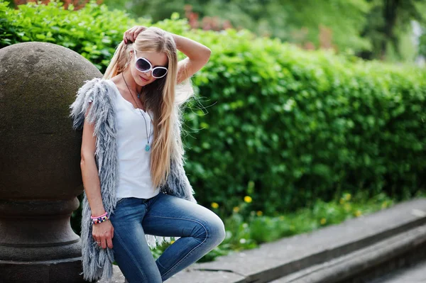 Stijlvolle blonde vrouw dragen op een jeans, zonnebril en meisje sleevele — Stockfoto