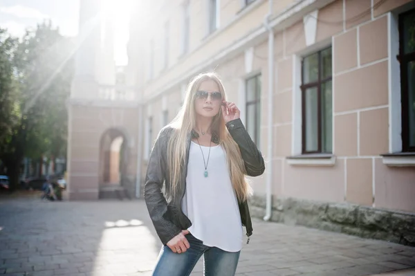 Snygg blond kvinna bär jeans, solglasögon och jacka poserade — Stockfoto