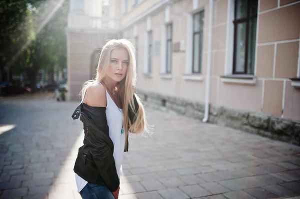 Stylische Blondine in Jeans, Sonnenbrille und Jacke posiert — Stockfoto