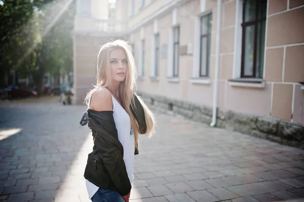 Stijlvolle blonde vrouw slijtage op jeans, zonnebril en jas gesteld — Stockfoto