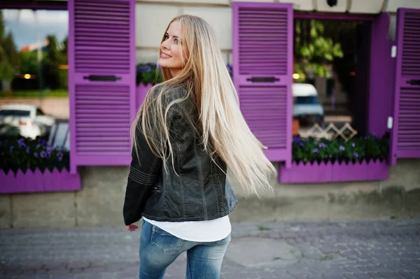 时髦的金发女人穿牛仔裤和夹克摆在街头 ag — 图库照片