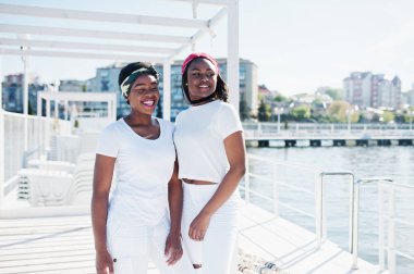 İki şık ve trendy Afro-Amerikan kız, beyaz clo aşınma