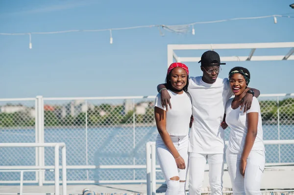 Tres elegantes amigos afroamericanos, usar en ropa blanca en — Foto de Stock