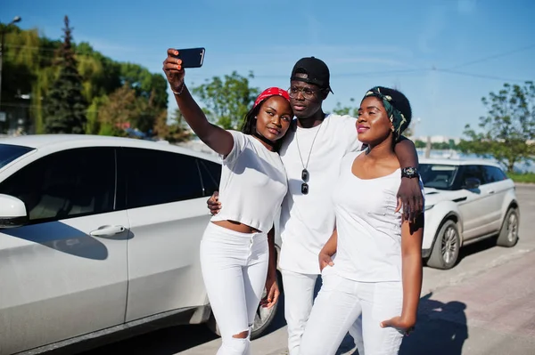 Three stylish african american friends making selfie on phone, w