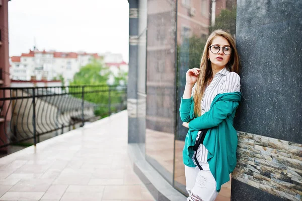 Trendig tjej på glasögon och rippade jeans mot hus på gatan. — Stockfoto