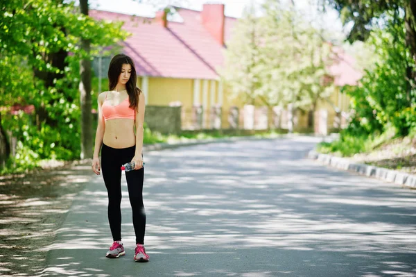 Fitness sport meisje in sportkleding met flesje water in de str — Stockfoto