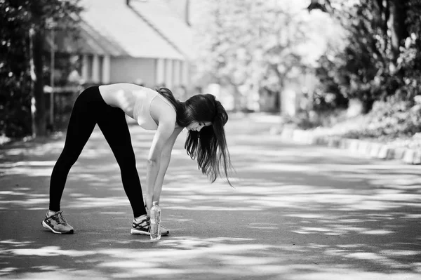 Fitness Sportovní dívka v oblečení s lahví vody dělá výkonu zde zarucených — Stock fotografie