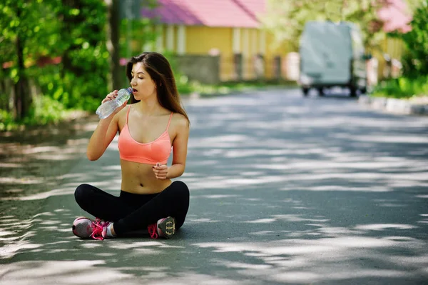 Fitness menina esporte em sportswear sentado na estrada na rua e d — Fotografia de Stock