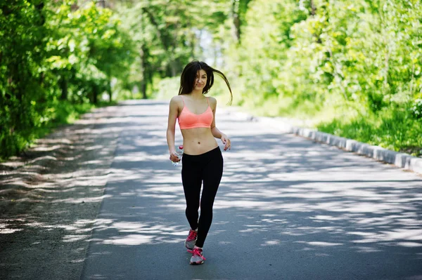 Fitness menina esporte em sportswear correr na estrada na floresta com bott — Fotografia de Stock