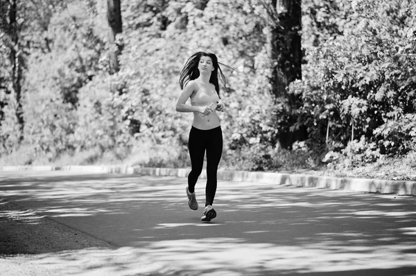Fitness menina esporte em sportswear correr na estrada na floresta com bott — Fotografia de Stock