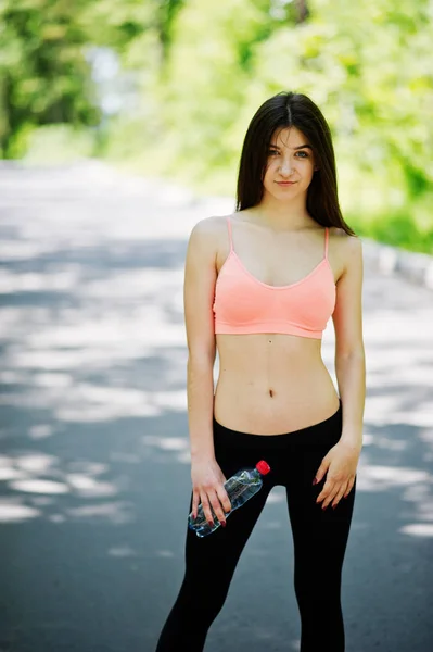 Fitness ragazza sportiva in abbigliamento sportivo in posa su strada nella foresta con bo — Foto Stock
