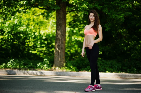 Fitness sport girl en ropa deportiva posado en la carretera en el parque, al aire libre — Foto de Stock