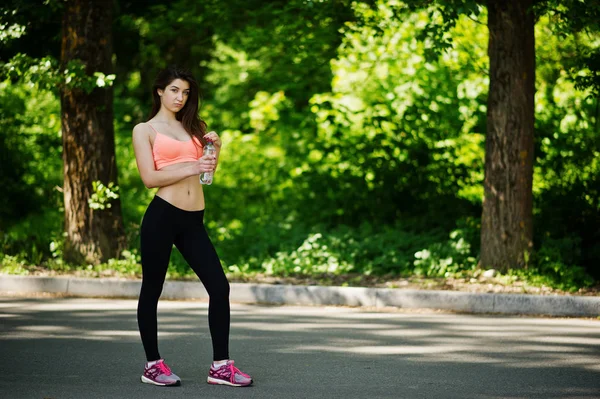 Fitness menina esporte em sportswear posou na estrada no parque com bott — Fotografia de Stock