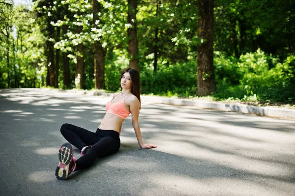 Fitness menina esporte em sportswear sentado na estrada no parque, outdoo — Fotografia de Stock