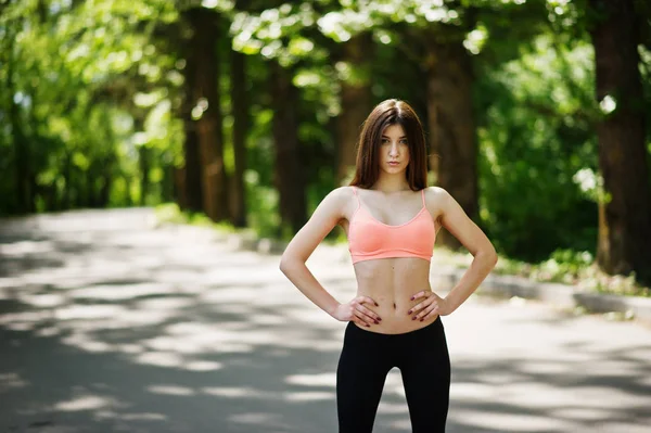 Fitness slim sexy menina esporte em sportswear posado na estrada no parque — Fotografia de Stock